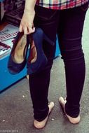 shoes with high heels in hand of barefeet girl