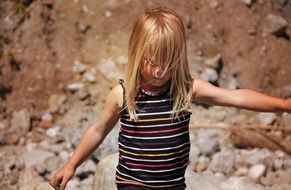Blonde girl is walking on the stones
