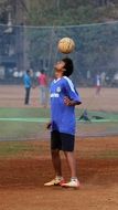 football, young dark skin man balancing ball on head