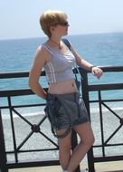 girl posing near a fence on a background of the sea