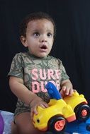 happy child playing with car toy