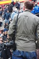 photographer with camera in crowd, back view