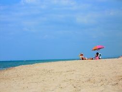 girl lying on a lounger under an umbrella