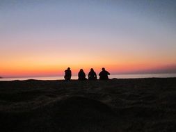 Silhouettes of people resting on the beach