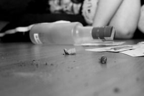 sleeping girl, empty bottle and cards on floor