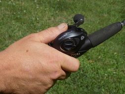 male hand holding fishing rod