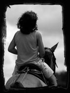 young boy on horse black and white