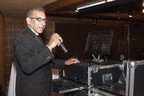 dj man with microphone at mixing desk