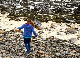 girl walking on the stone coastline