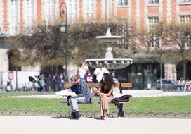 people on a bench near the fountain