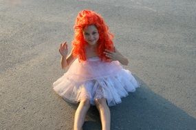 a child with red hair like a doll