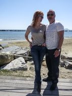 couple on a wooden floor by the sea