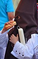 man in a mask is eating hotdog