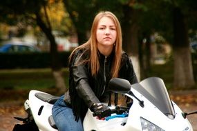 blonde in a leather jacket on a motorcycle