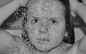 Monochrome portrait of child with shower drop