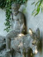 man riding donkey, stone sculpture outdoor