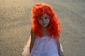 baby girl with red hair in a white dress like a doll