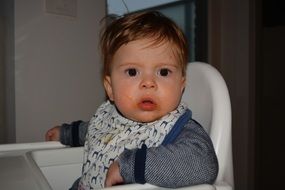 cute boy sitting on white chair