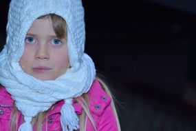 blue eyes girl face in white cap dark back