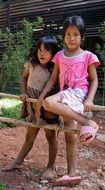 two asian child girls at fence, Cambodia