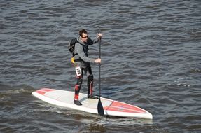 Photo of standing man on the surf board