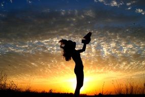 girl silhouette on sunset background