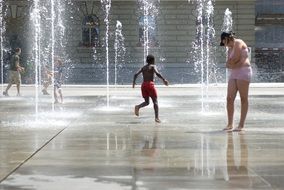 kids playing in fountain on plaza