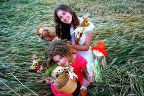 cheerfulness girls playing dolls on the background of summer nature