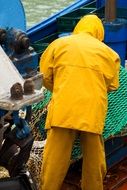 fisherman in a yellow suit on the ship