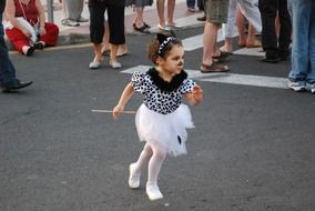 little girl in cat costume runs on the road