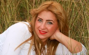 blonde with green eyes on a grass background