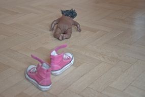 doll on the floor near the girls shoes