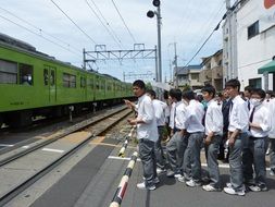 students at a railway crossing in Japan