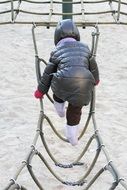 child is climbing a rope ladder