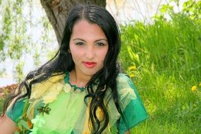 girl sitting on the grass on a background of lake