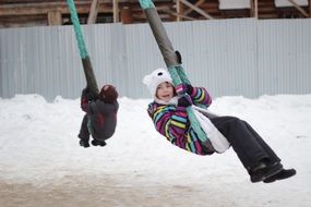 happy Children ride on the carousel in winter