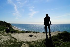 back view of photographer on coast at sea