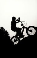 silhouette of a man riding on a bicycle