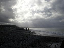boys on the beach of the ocean during storm