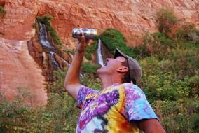 man with a can of beer on the background of fresh water in the Grand Canyon