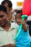 dad holds baby with a balloon