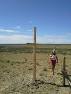 lonely woman near the cross on a sunny day