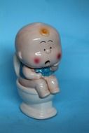 ceramic child figurine on the toilet