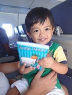 the boy in the arms of his parents on the plane