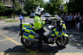 policeman on bike in city, uk, england