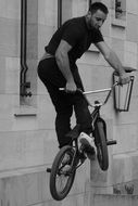 Black and white image of a man in a bicycle jump