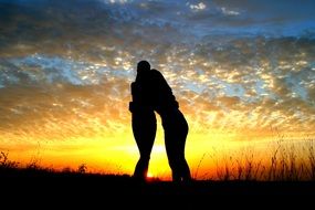 silhouettes of friendly people on the sunset background