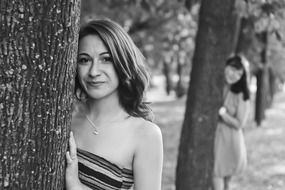 two girls behind trees, Black and white