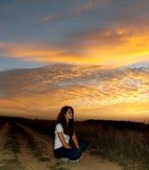 beautiful brunette girl on the background of bright sunset