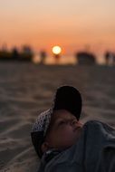 child on the sand at sunset